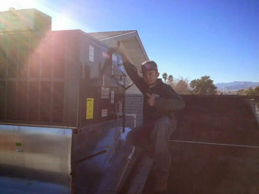 HVAC technician performing Air Duct Repair on a rooftop unit in Irvine